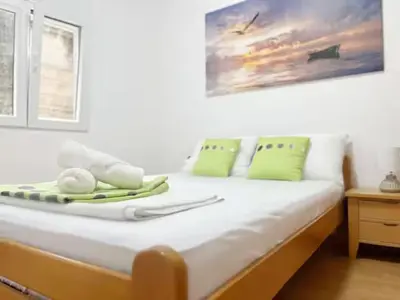a bed with green and white items on it at Asia Apartments in Škaljari