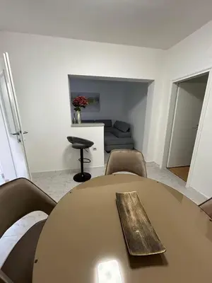a table and chairs in a room with a couch at Asia Apartments in Škaljari