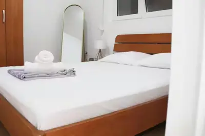 a bedroom with a large bed with a mirror at Asia Apartments in Škaljari