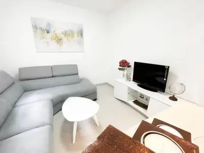 a living room with a couch and a tv at Asia Apartments in Škaljari