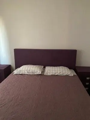 a bedroom with a bed with a purple headboard at Bigova Peace Oasis in Bigovo
