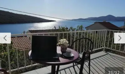 a table with a laptop on top of a balcony at Bigova Peace Oasis in Bigovo