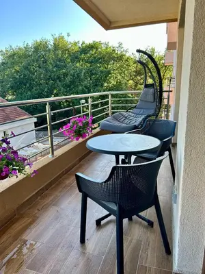 two tables and chairs on a balcony with flowers at Heart of Budva 3BR City View Apt in Budva