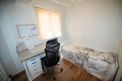 a bedroom with a desk and a bed and a desk chair at Heart of Budva 3BR City View Apt in Budva
