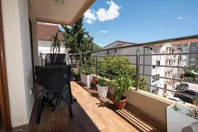 a balcony with a chair and potted plants on it at Heart of Budva 3BR City View Apt in Budva
