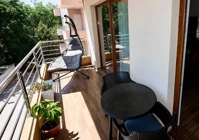a balcony with a black table and chairs on it at Heart of Budva 3BR City View Apt in Budva