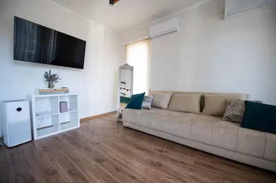 a living room with a couch and a flat screen tv at Heart of Budva 3BR City View Apt in Budva