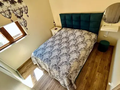 a small bedroom with a bed and a window at Heart of Budva 3BR City View Apt in Budva