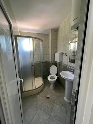 a bathroom with a shower and a toilet and a sink at Apartmani Zlatičanin in Sutomore