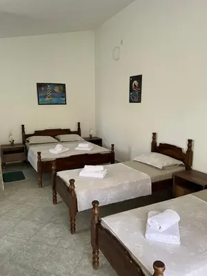 a room with three beds in a room at Apartmani Zlatičanin in Sutomore