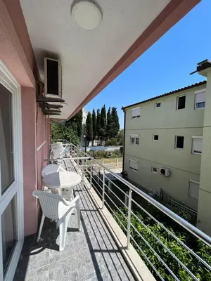 a balcony with a table and chairs on a building at Apartmani Zlatičanin in Sutomore