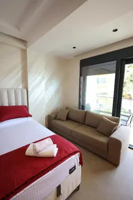 a bedroom with a large bed and a couch at Ornament Liman - Infinity Pool with Old Town View Apartments in Ulcinj
