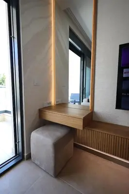 a room with a mirror and a bench and a window at Ornament Liman - Infinity Pool with Old Town View Apartments in Ulcinj