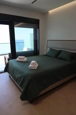 a bedroom with a bed with two towels on it at Ornament Liman - Infinity Pool with Old Town View Apartments in Ulcinj