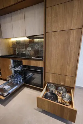a kitchen with wooden cabinets and a drawer with pots and pans at Ornament Liman - Infinity Pool with Old Town View Apartments in Ulcinj