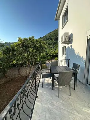 a patio with a table and chairs on a balcony at Apartmani Aki 1 in Sutomore