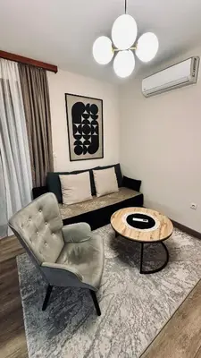 a living room with a couch and a table and a chair at Central Station Apartments in Podgorica