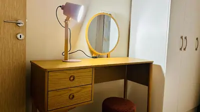 a dressing table with a mirror and a lamp on it at Central Station Apartments in Podgorica