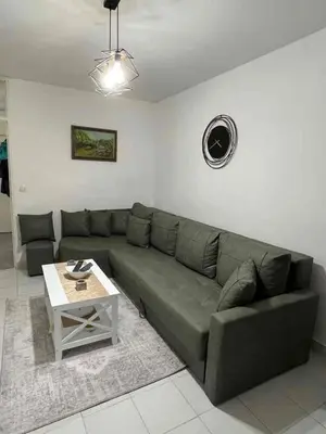 a living room with a green couch and a table at Sivas Bar in Bar