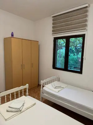 a room with two beds and a window at Apartman Pod lozom in Sutomore