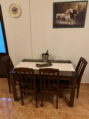a dining room table and chairs with a horse painting on the wall at Apartman Pod lozom in Sutomore