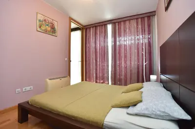 a bedroom with a bed and a large window at Central lux apt with garage in Budva