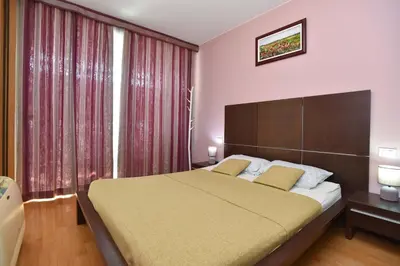 a bedroom with a large bed and a large window at Central lux apt with garage in Budva
