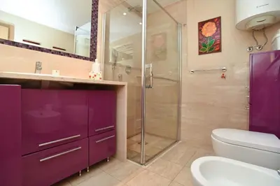 a purple bathroom with a shower and a toilet at Central lux apt with garage in Budva