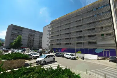 a parking lot with cars parked in front of a building at Central lux apt with garage in Budva