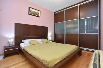 a bedroom with a large bed with a wooden headboard at Central lux apt with garage in Budva