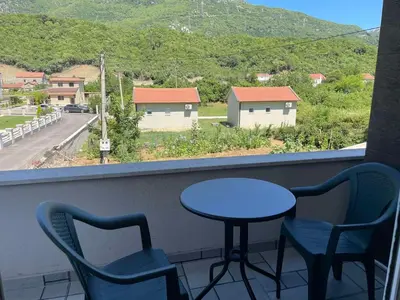 a table and chairs on a balcony with a view at Greystone House Apartments in Kovači