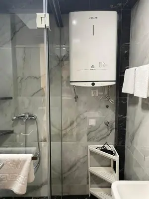 a bathroom with a glass shower and a sink at Greystone House Apartments in Kovači