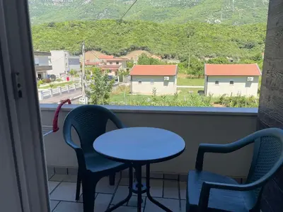 a table and two chairs in a room with a window at Greystone House Apartments in Kovači