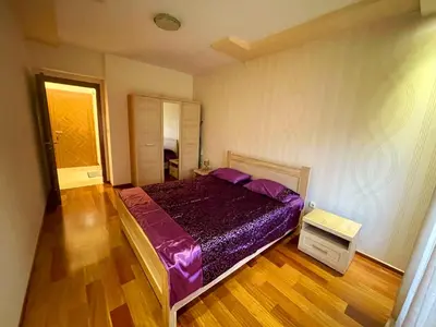 a bedroom with a purple bed and a wooden floor at CENTRAL apartment in Podgorica