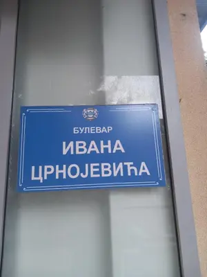 a blue street sign on the side of a building at CENTRAL apartment in Podgorica