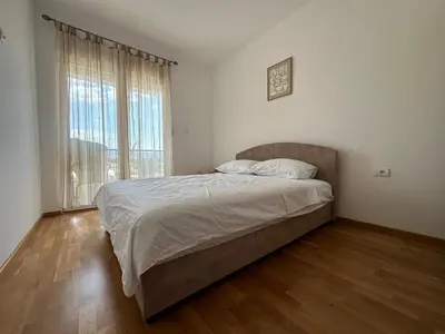 a bedroom with a bed and a large window at Modern 2BR - Smart TV and WiFi in Podgorica
