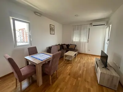 a living room with a table and a couch at Modern 2BR - Smart TV and WiFi in Podgorica