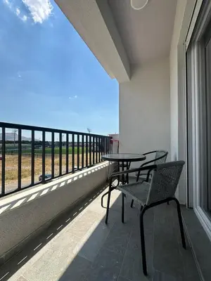 a table and chair on a balcony with a view at Modern 2BR - Smart TV and WiFi in Podgorica