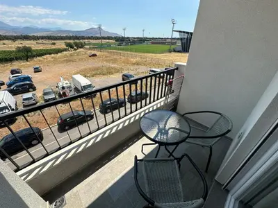 a balcony with two chairs and a view of a parking lot at Modern 2BR - Smart TV and WiFi in Podgorica