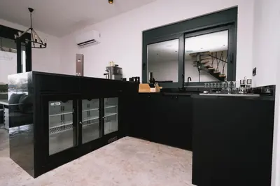 a kitchen with black cabinets and a large window at Casa Rio in Ulcinj