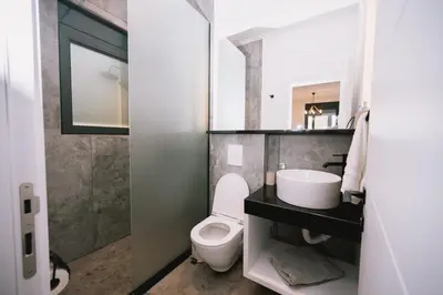 a bathroom with a white toilet and a sink at Casa Rio in Ulcinj