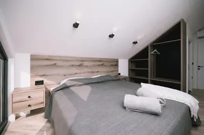 a bedroom with a bed and a wooden wall at Casa Rio in Ulcinj