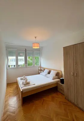 a bedroom with a large bed and a cabinet at Top-Top 2 in Podgorica