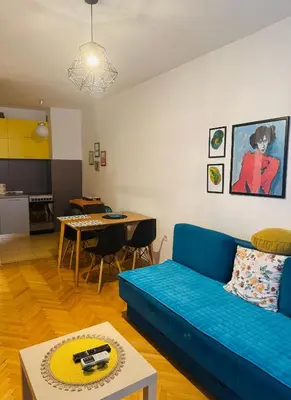 a living room with a blue couch and a table at Top-Top 2 in Podgorica
