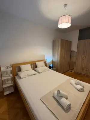 a bedroom with a large bed with towels on it at Top-Top 2 in Podgorica