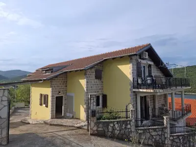 a small yellow house with a balcony at Apartment Bigovo in Tivat