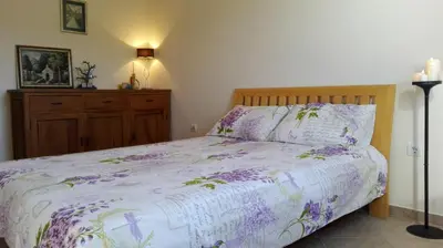 a bedroom with a bed with purple flowers on it at Apartment Bigovo in Tivat