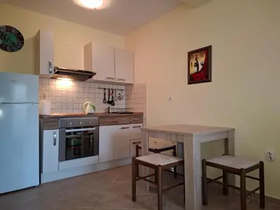 a kitchen with a table and a refrigerator at Apartment Bigovo in Tivat