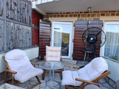 a patio with two chairs and a table and a fan at Apartment Bigovo in Tivat