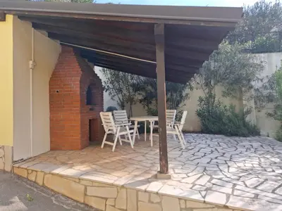a patio with a table and chairs under a roof at Apartment Bigovo in Tivat